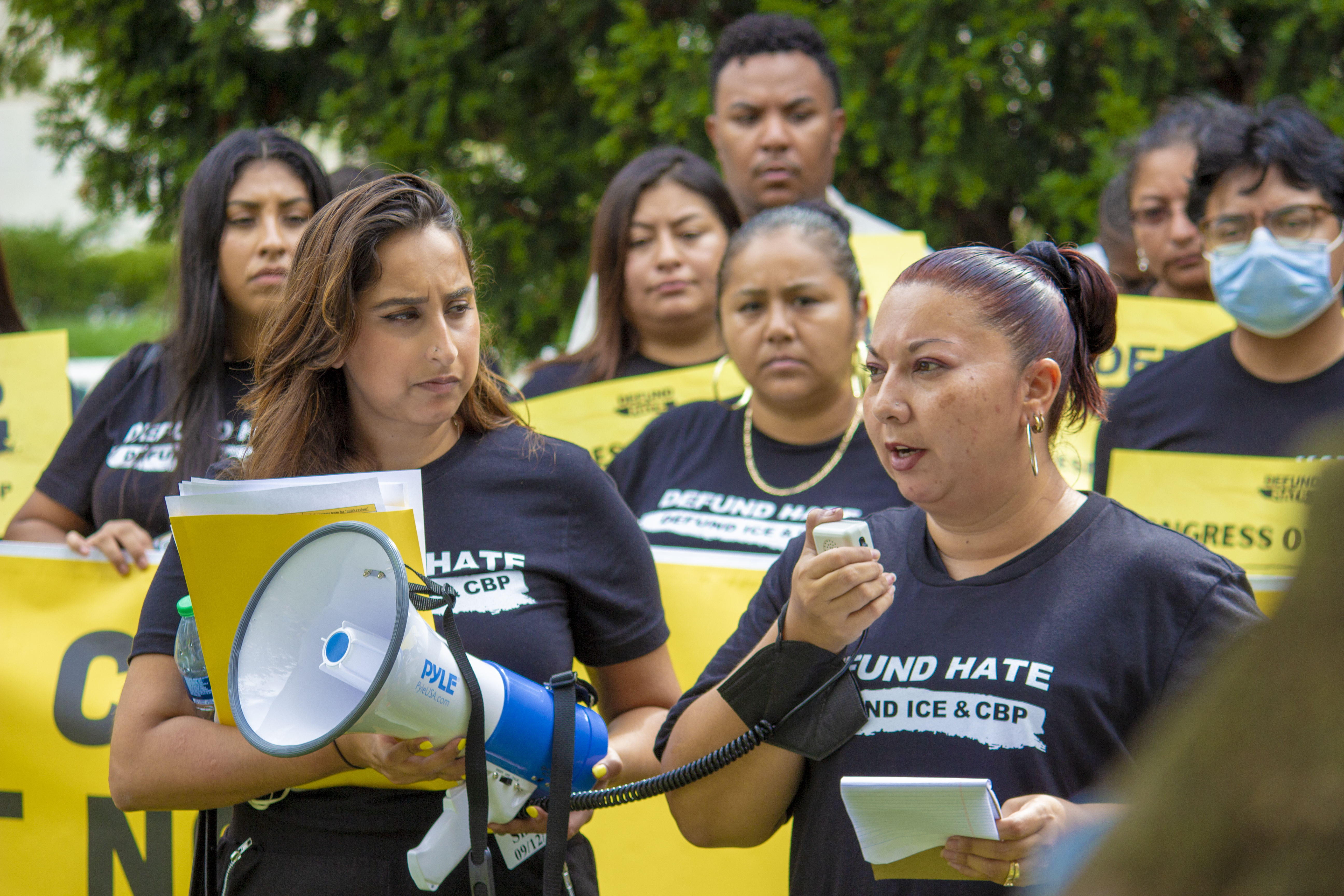 Woman addressing a rally with people holding signs