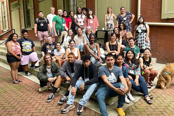 A large group of program participants sit on steps outside the AFSC office in Philadelphia