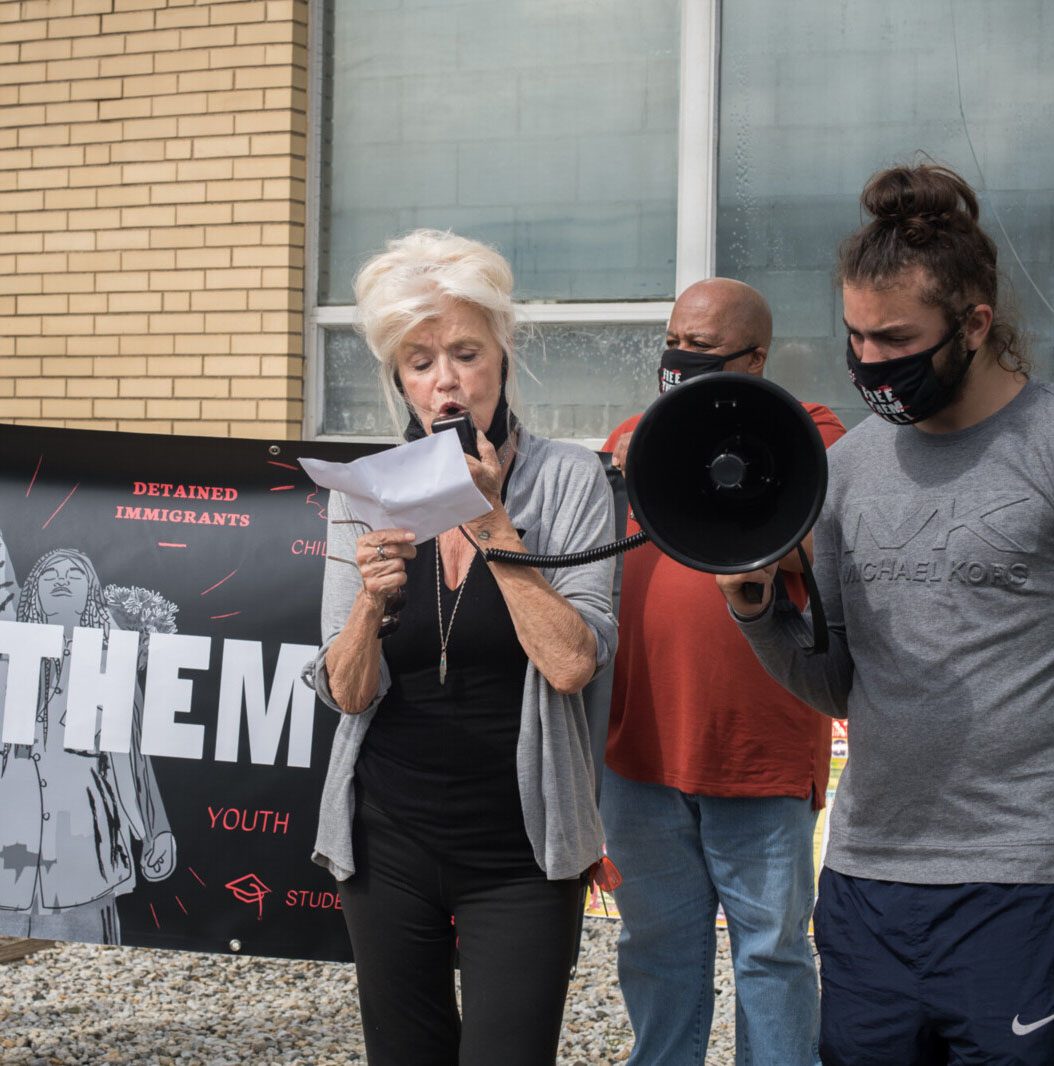 Bonnie in front of megaphone reading off of a piece of paper