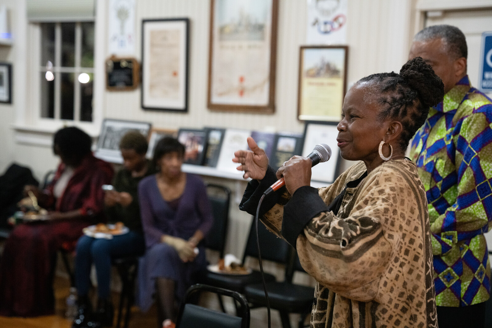 woman speaking in front of crowd holding a microphone