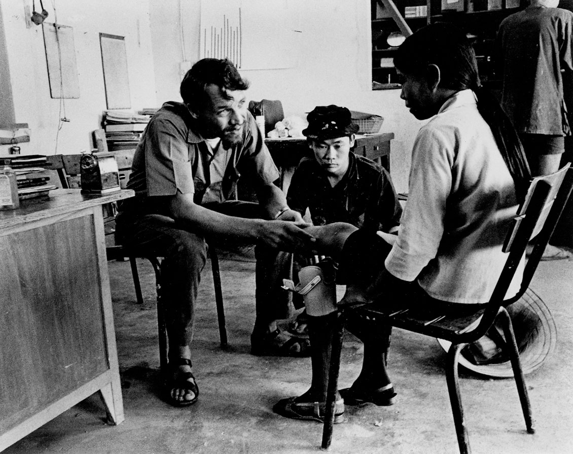 Man attending to a patient sitting on a chair