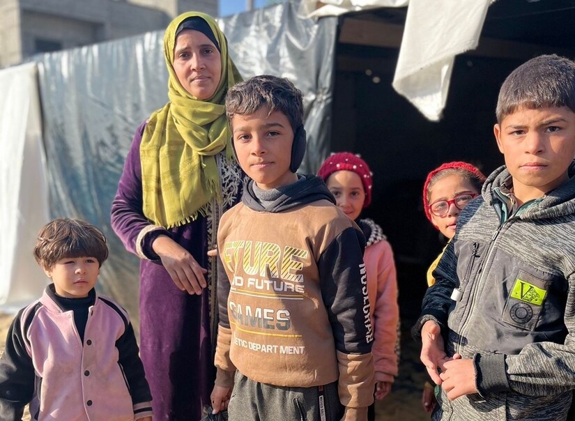 A mother and five children in front of a tent