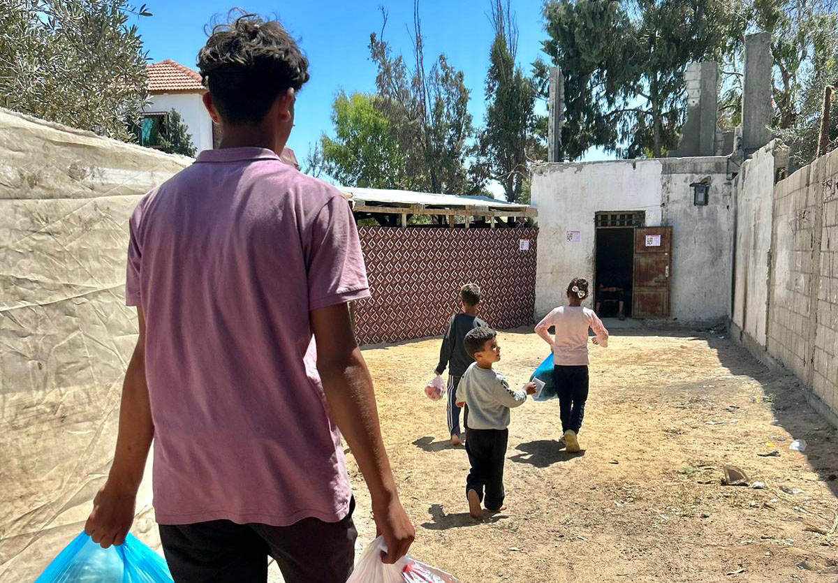 Man walking toward an open door with children running in front of him