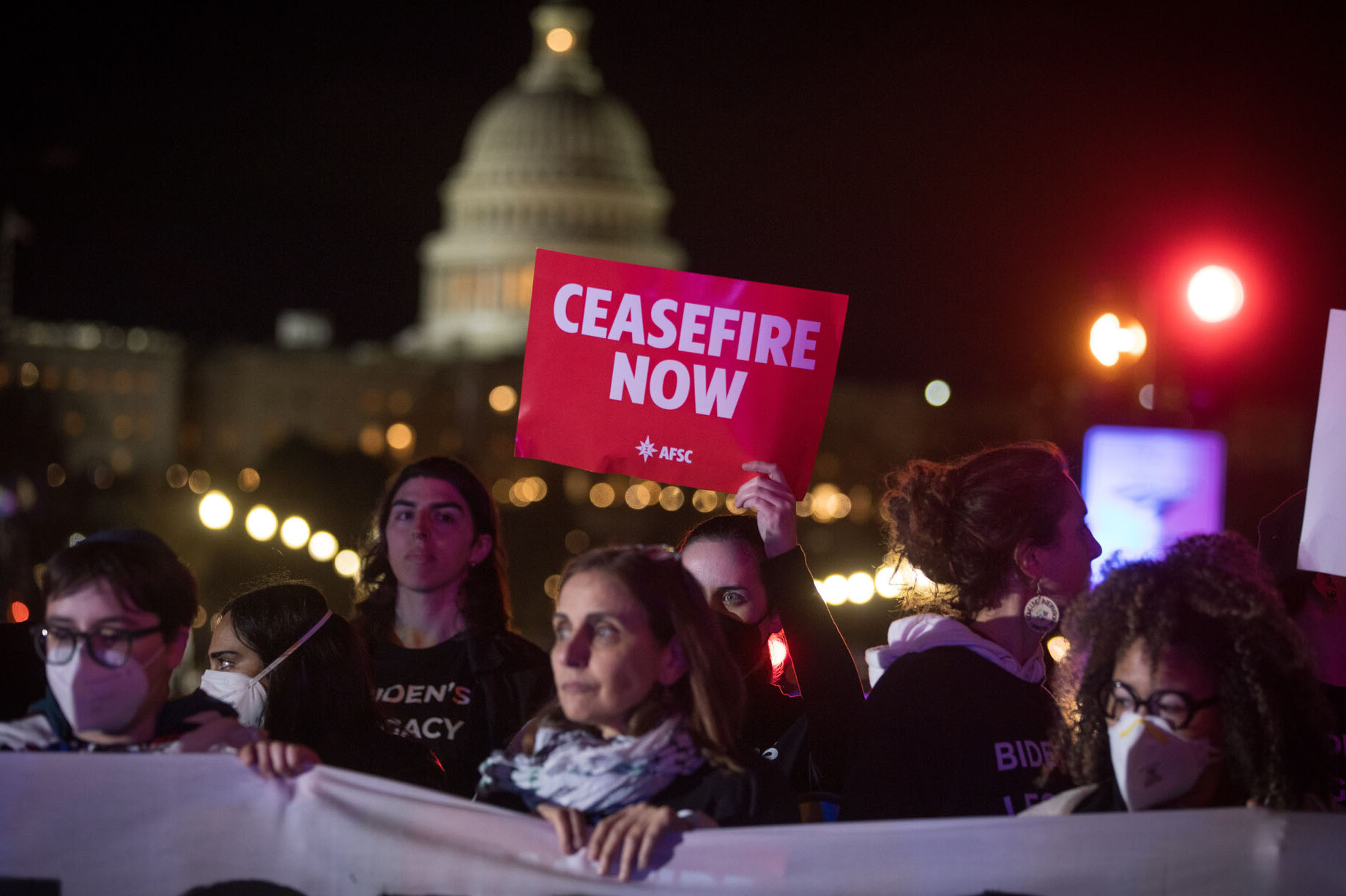 Joyce Ajlouny standing in front of the capitol with a Ceasefire Now sign behind her