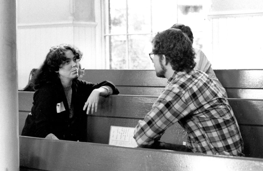 Two people facing each other on a bench