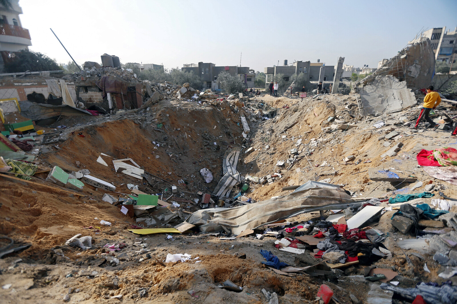 Palestinians inspect the location of an Israeli air strike in Rafah