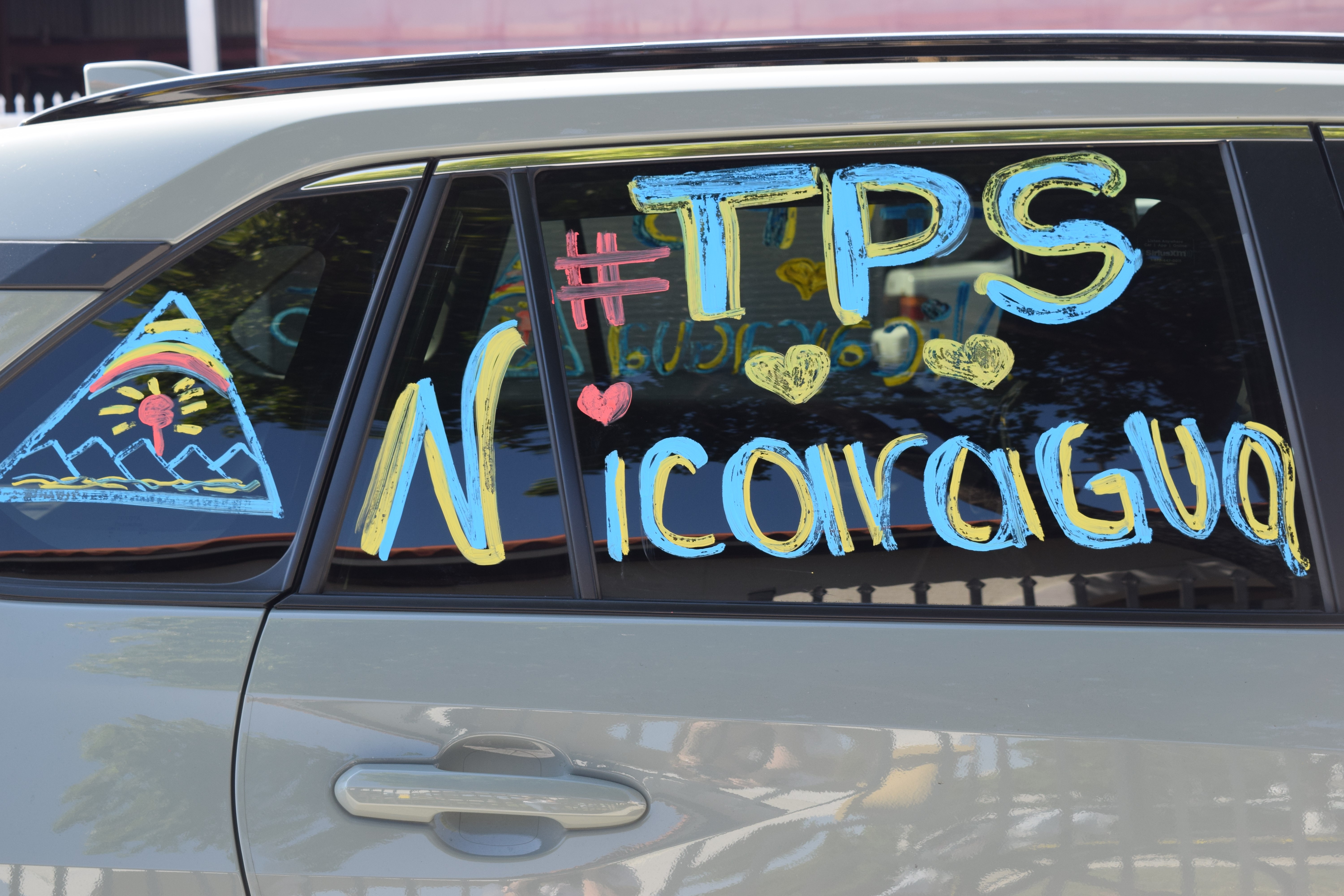 Image of '#TPS Nicaragua' painted on a car window