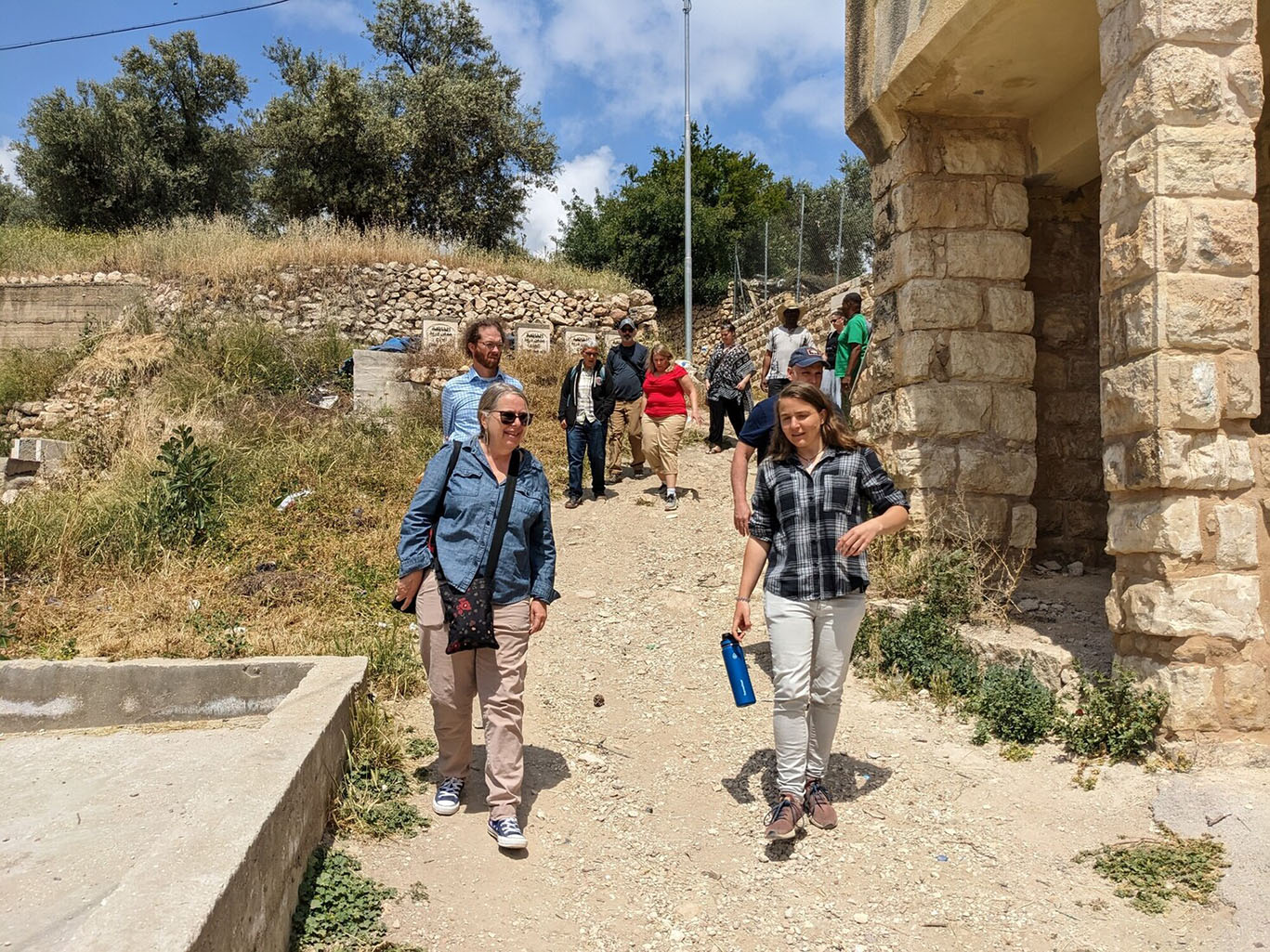 A group of people walk down a sandy hill in Palestine