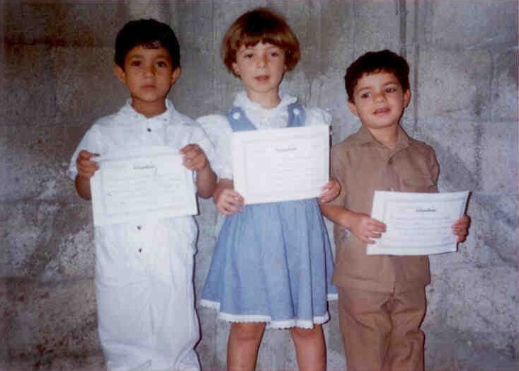 Three children holding up paper certificates