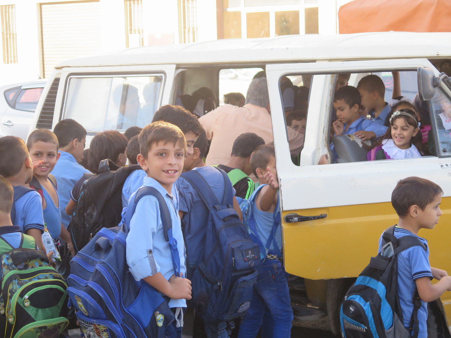 School children line up for a crowded bus in Gaza