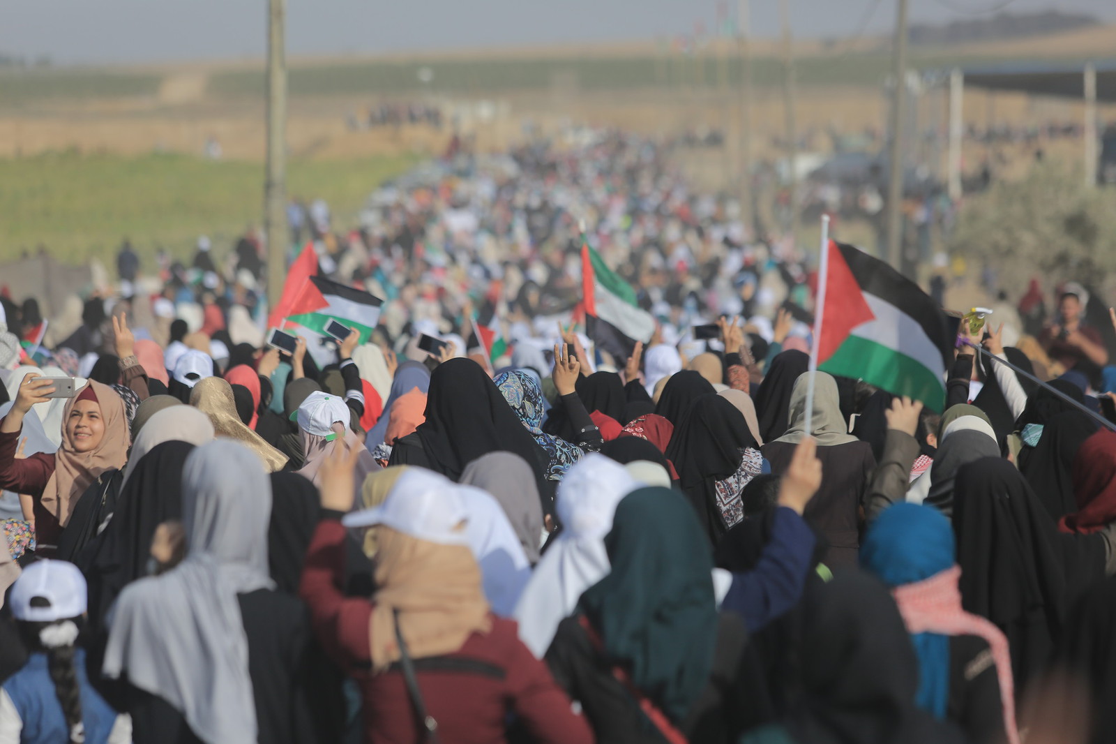 Large group of Palestinian protesters at a border fence