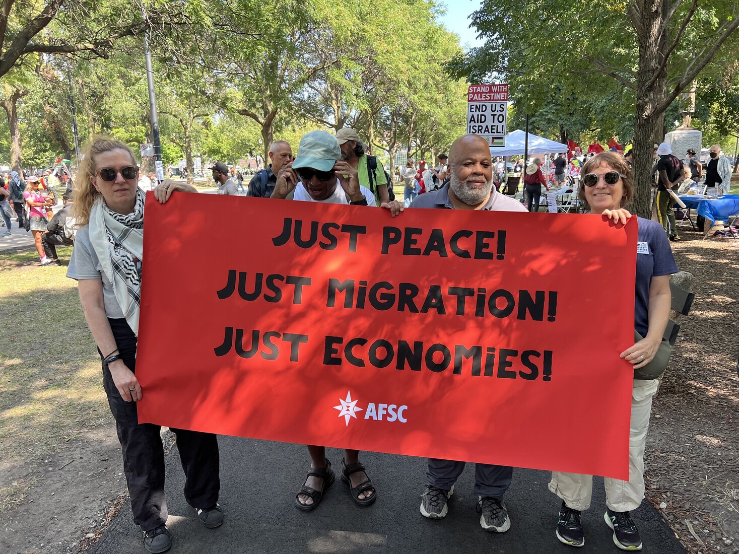 People holding banner that says Just Peace / Just Immigration / Just economies