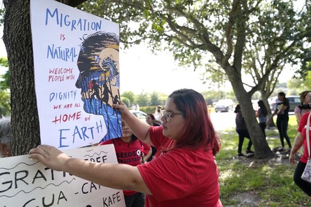 Woman puts up sign on tree